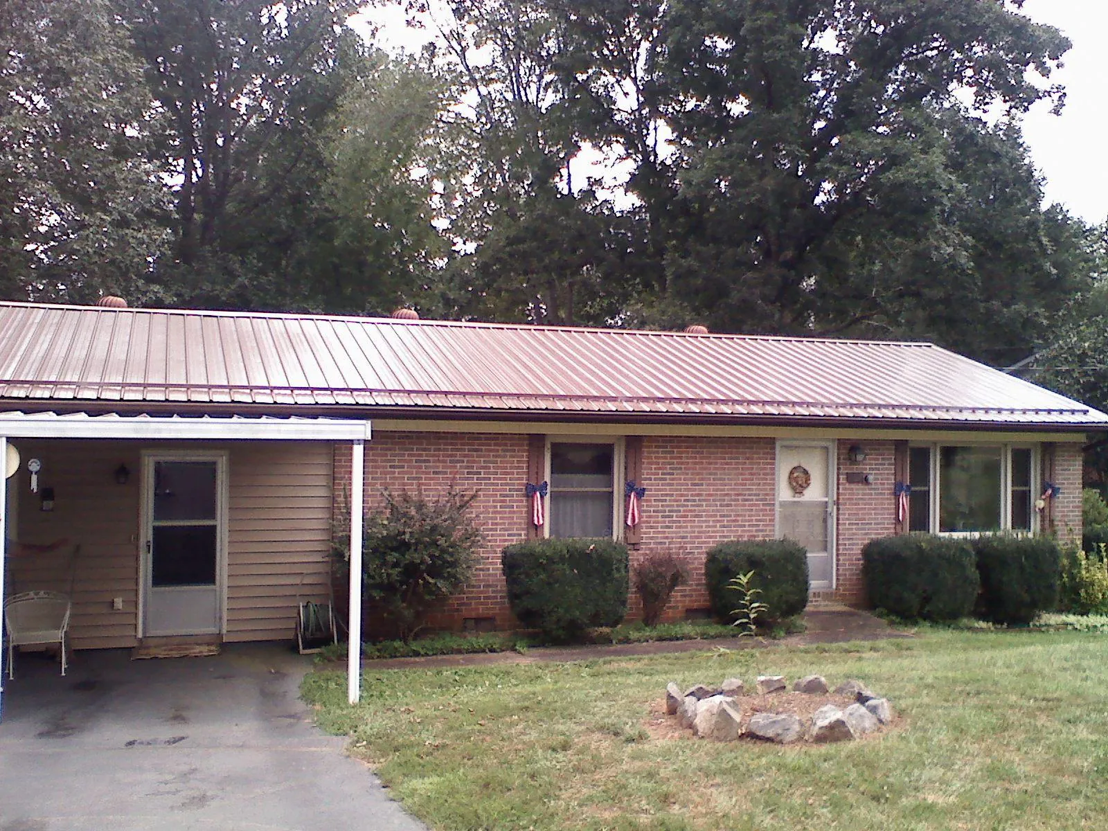 Bronze metal roof and carport on a brick ranch home — Roof Repair work by our crew in Bay City