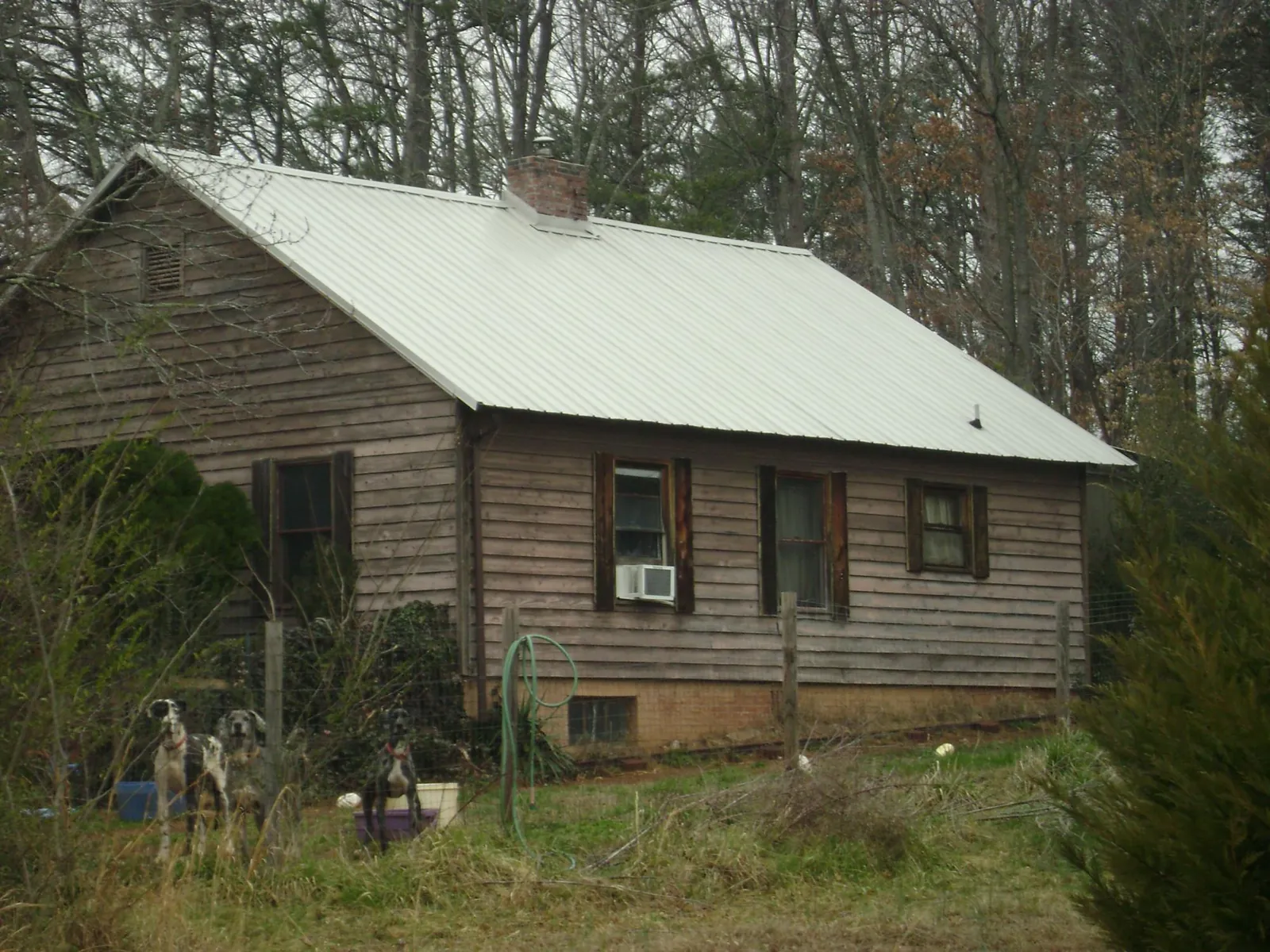 White metal roof on an old wood sided farmhouse, from a Metal Roof Installation job in Bay City